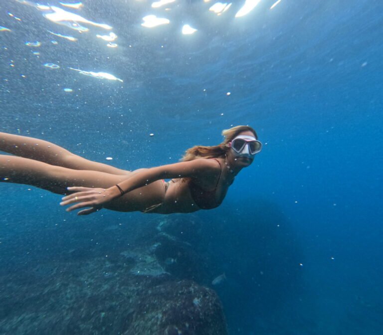 Woman snorkelling underwater with a diving mask