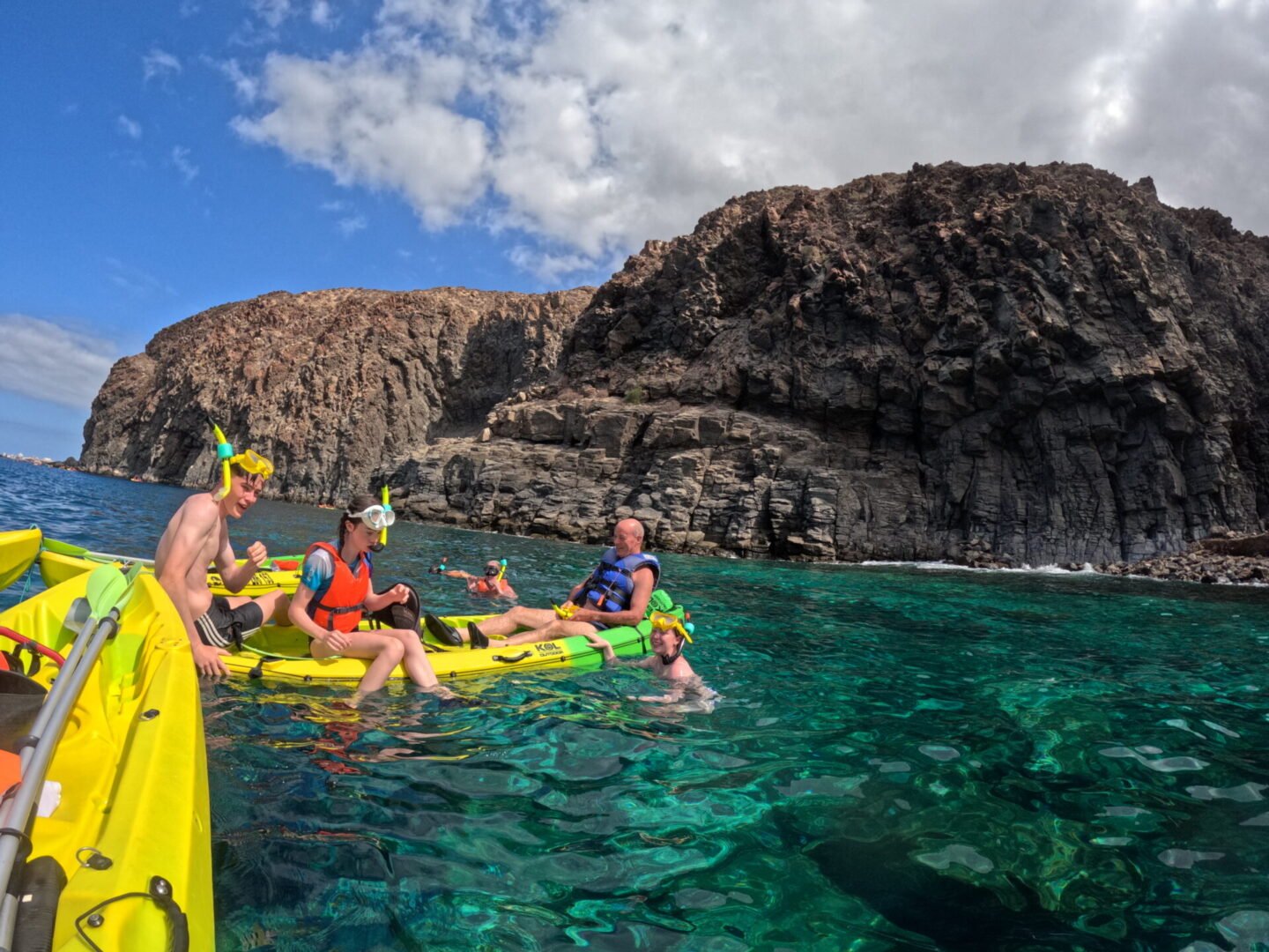 Gruppo in kayak accanto alla roccia vulcanica di Mal País, su acque verdi e trasparenti