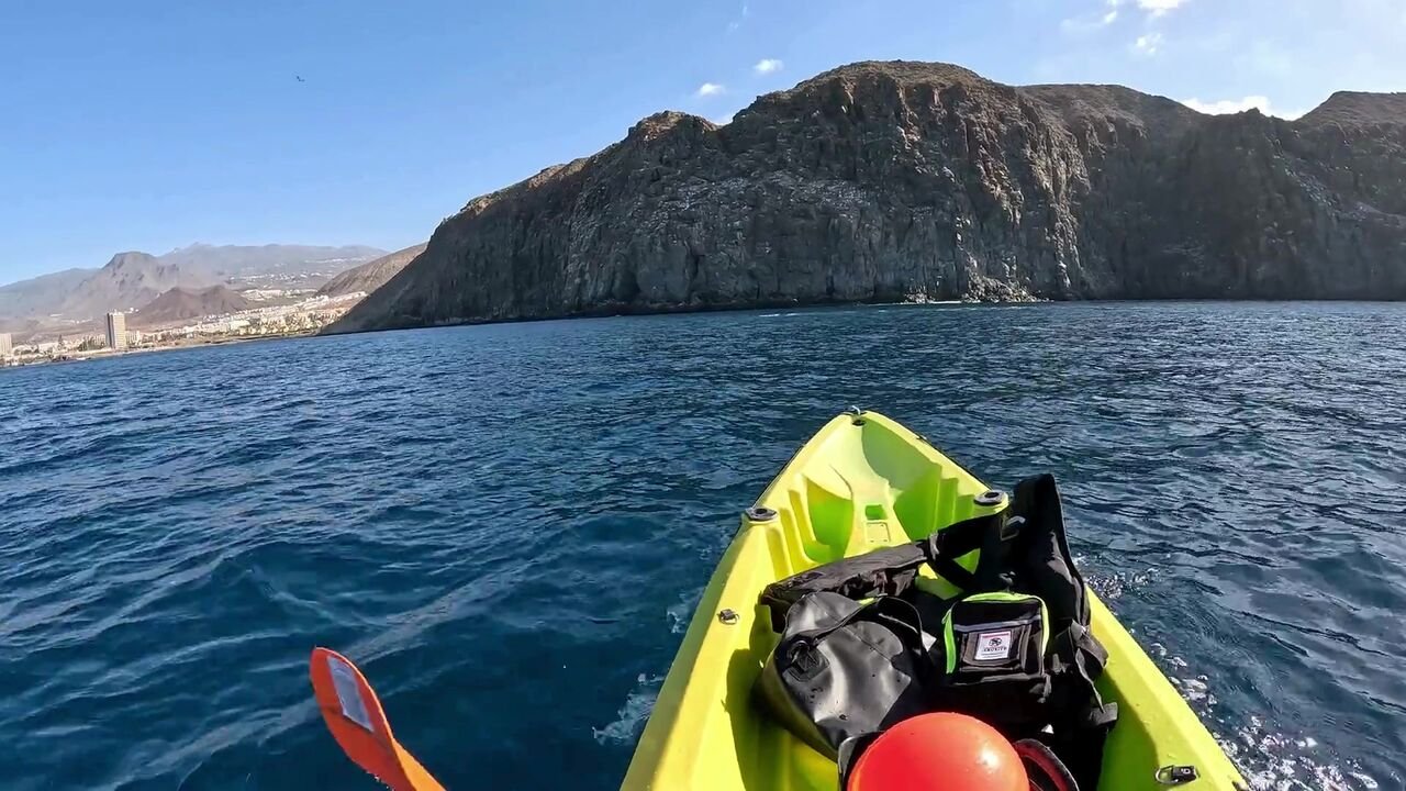 Kayak giallo che pagaia verso le scogliere vulcaniche di Palm-Mar