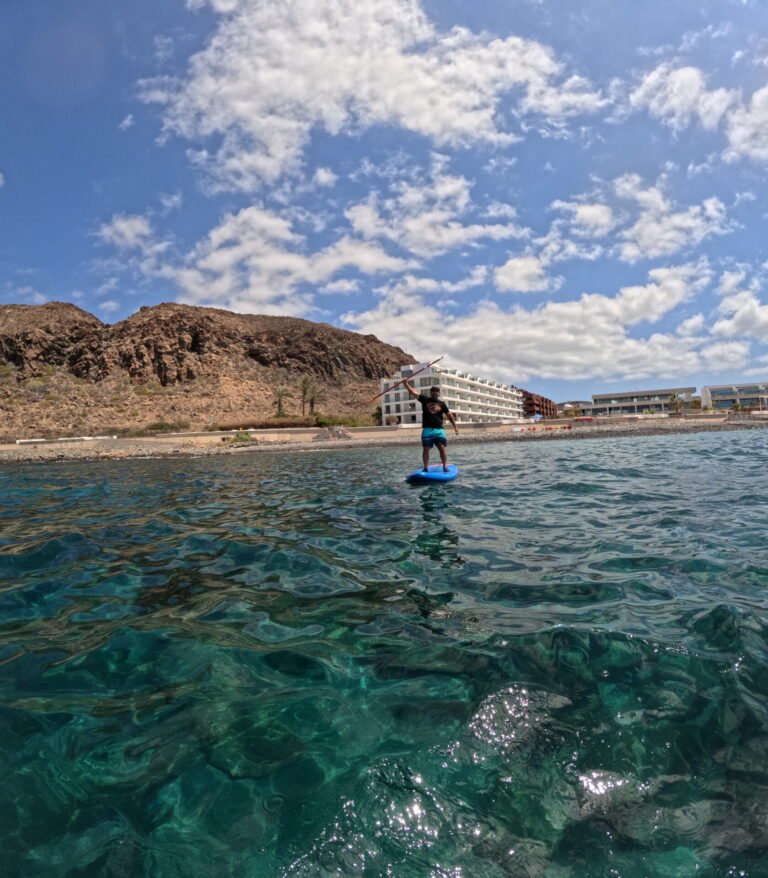 Paddle surfing in clear water off the coast of Palm-Mar